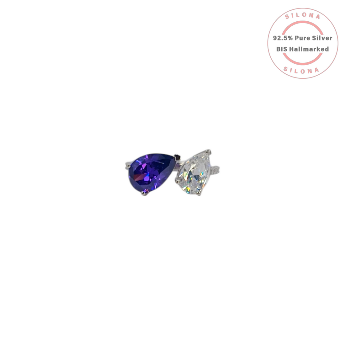 Silona's Toi et Moi ring featuring a pear-cut amethyst-hue cubic zirconia and a clear cubic zirconia, set in 92.5 sterling silver on a white background.