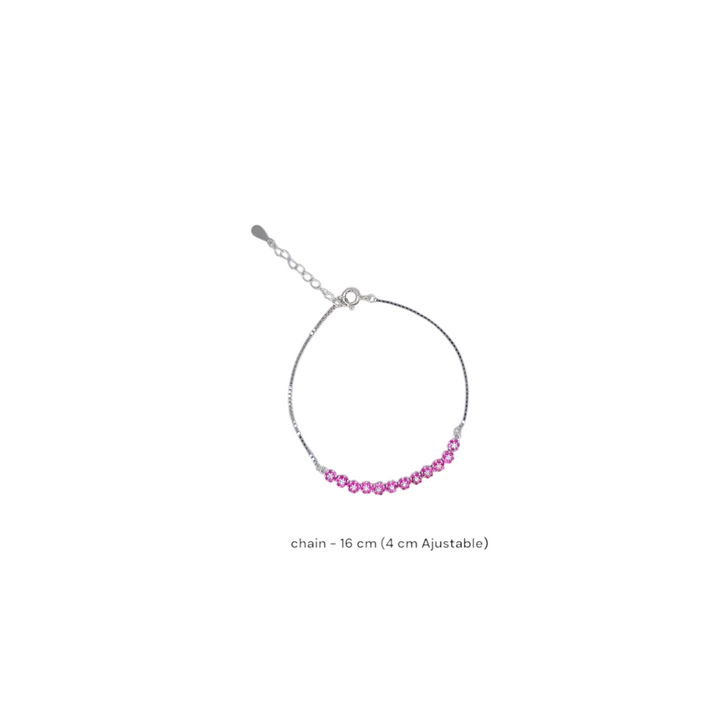 Delicate silver tennis bracelet featuring a row of round-cut pink sapphire hue cubic zirconia stones on a white background.