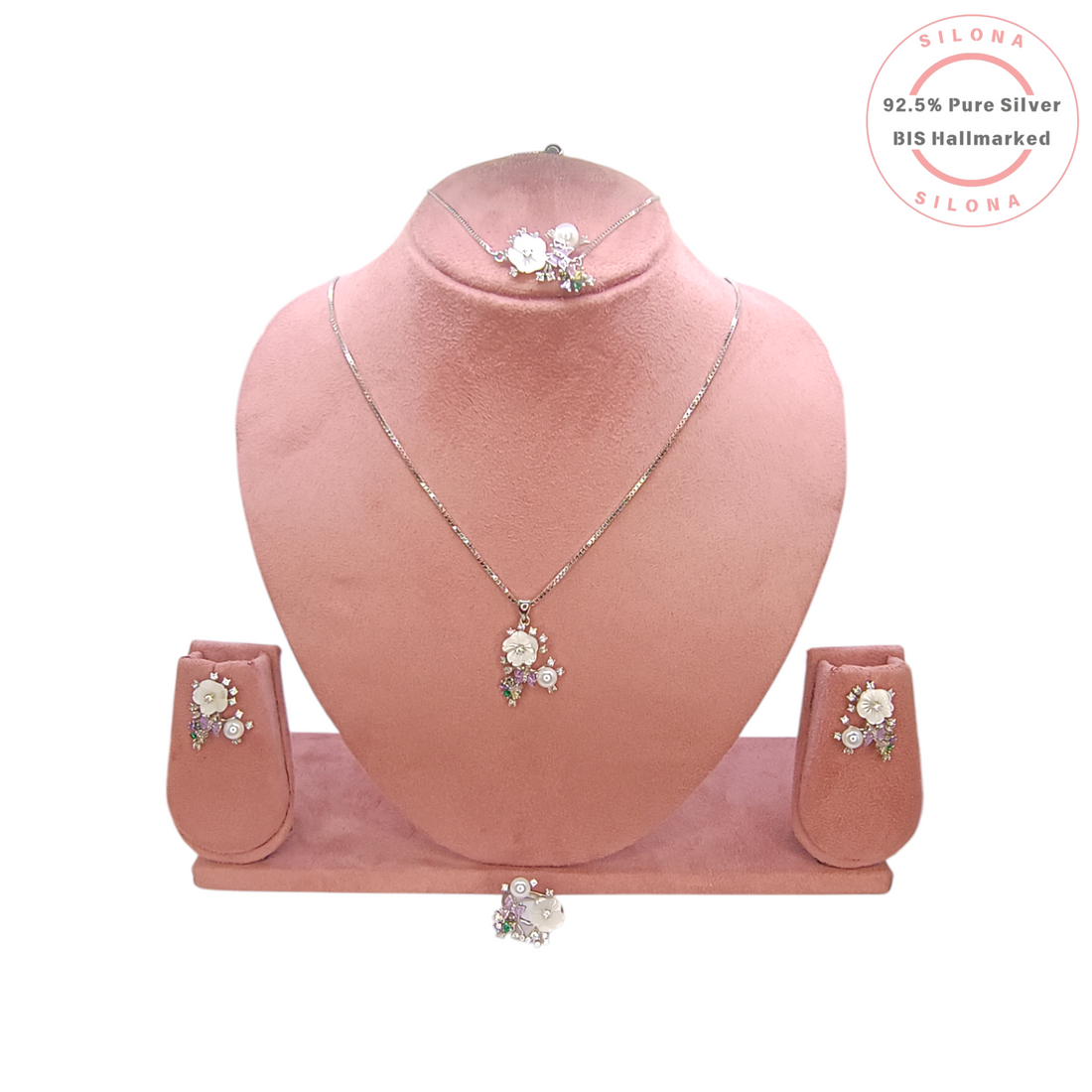 Silona's Floral Bouquet necklace and earring set in 92.5 silver, featuring mother-of-pearl flowers, a pearl, and pastel stones, displayed on a pink bust.