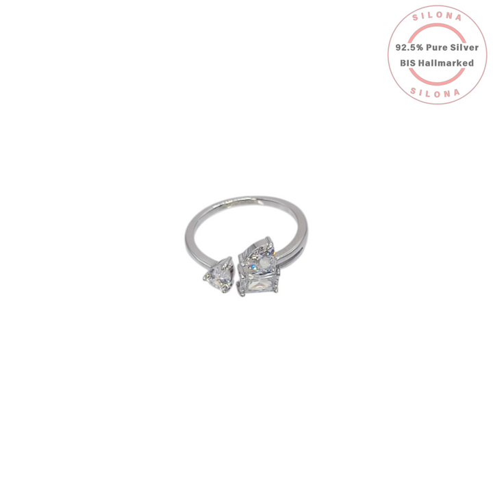 A modern crossover silver ring featuring three multi-shape clear cubic zirconia stones—a pear cut and a princess cut—on a polished band.