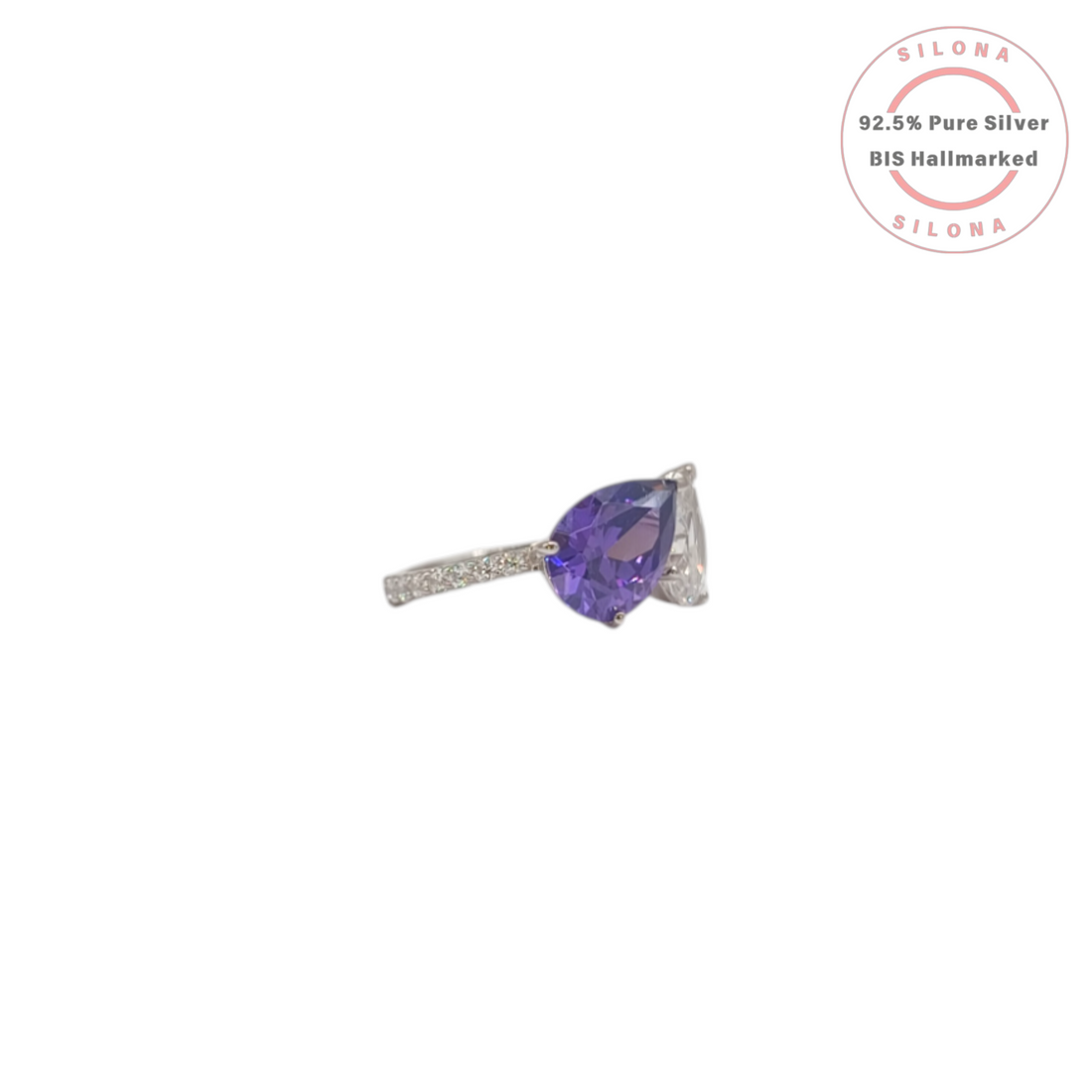 Silona's Toi et Moi ring featuring a pear-cut amethyst-hue cubic zirconia and a clear cubic zirconia, set in 92.5 sterling silver on a white background.