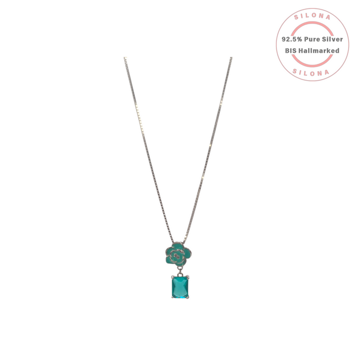 A sterling silver box chain necklace with a teal enamel rose and a dangling rectangular teal gemstone, on a white background.