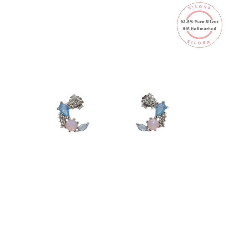 Pair of Pastel Aurora Crescent Stud Earrings in 92.5 silver, featuring a cluster of blue, pink, and clear cubic zirconia stones on a white background.