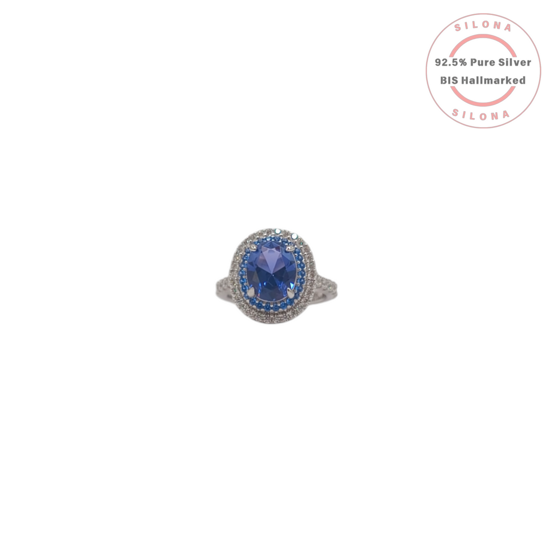 A royal blue tanzanite-hue cubic zirconia ring with a double halo of blue and clear stones, crafted in 92.5 sterling silver, shown on a white background.