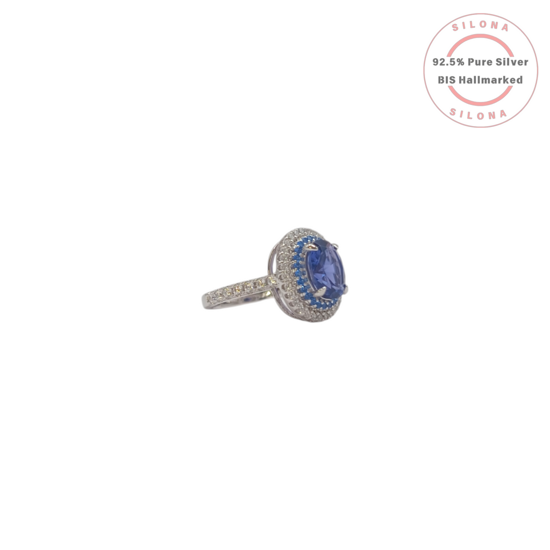 A royal blue tanzanite-hue cubic zirconia ring with a double halo of blue and clear stones, crafted in 92.5 sterling silver, shown on a white background.