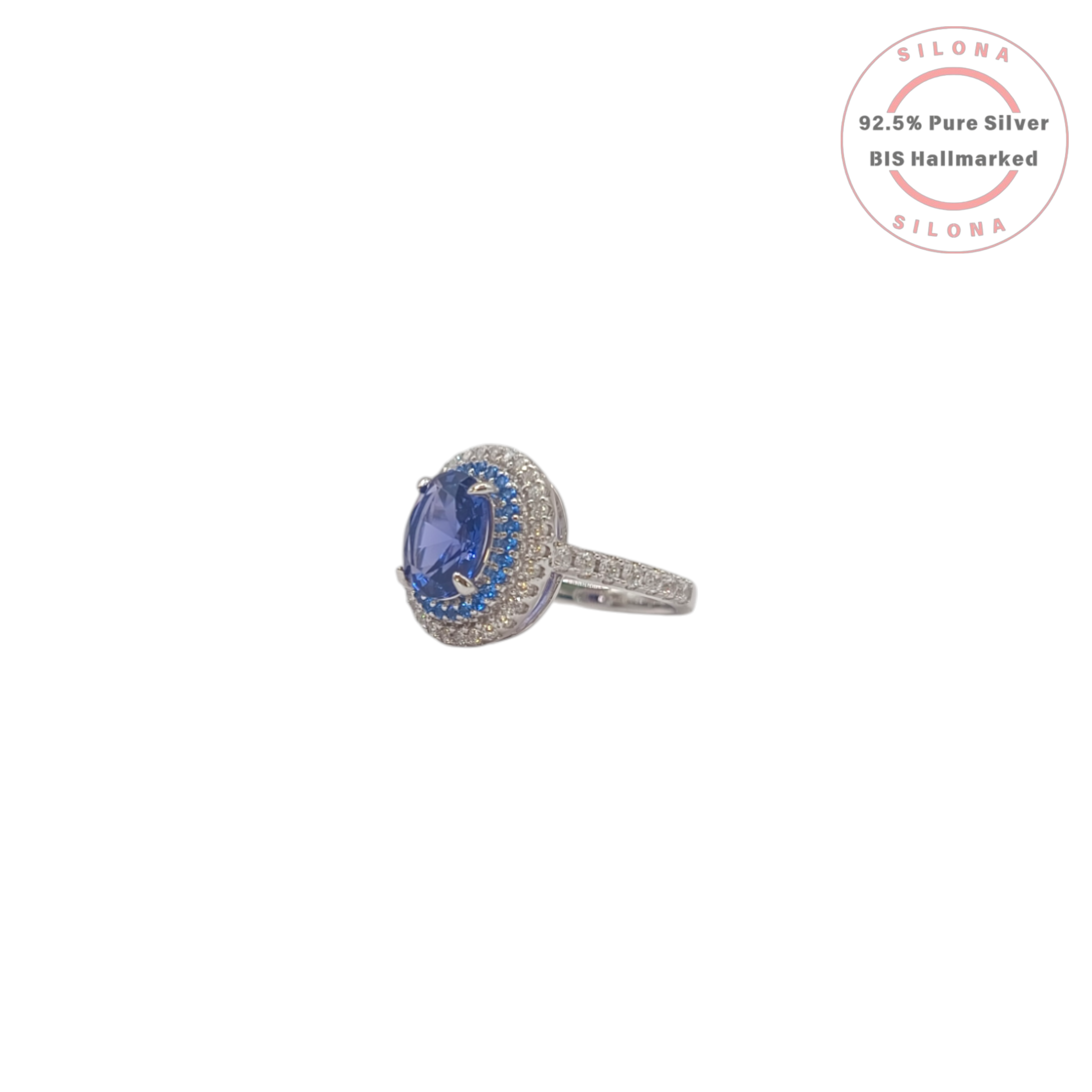 A royal blue tanzanite-hue cubic zirconia ring with a double halo of blue and clear stones, crafted in 92.5 sterling silver, shown on a white background.