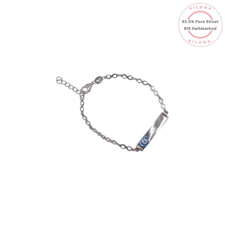 A delicate silver infinity-link chain bracelet with a central bar featuring a blue and white evil eye motif, on a clean white background.
