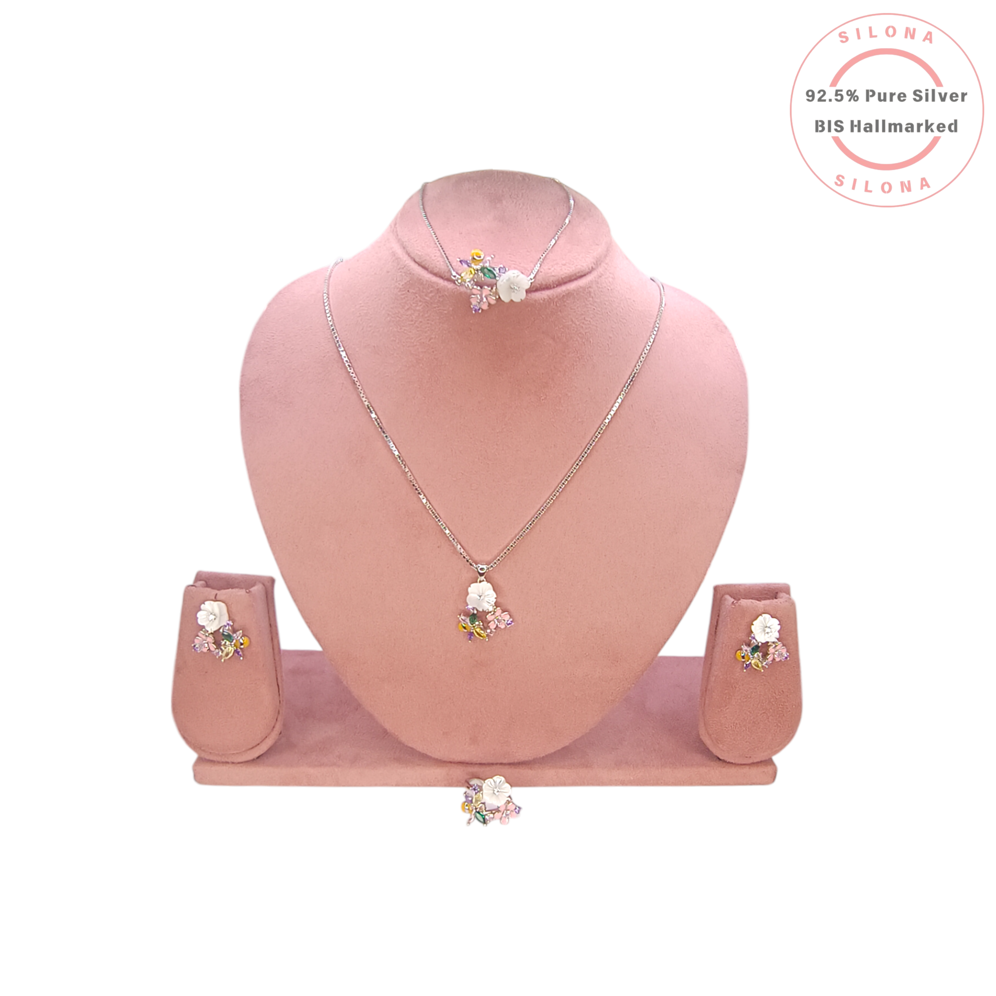 A floral jewellery set featuring a ring and two matching earrings with multi-colored stones, including a carved white flower and a pink enamel flower, on a white background with a Silona logo.