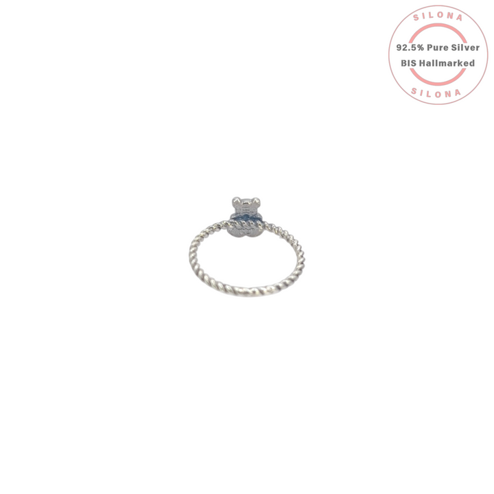 A whimsical teddy bear ring with a vibrant turquoise heart, crafted from 92.5 sterling silver with a twisted band design.