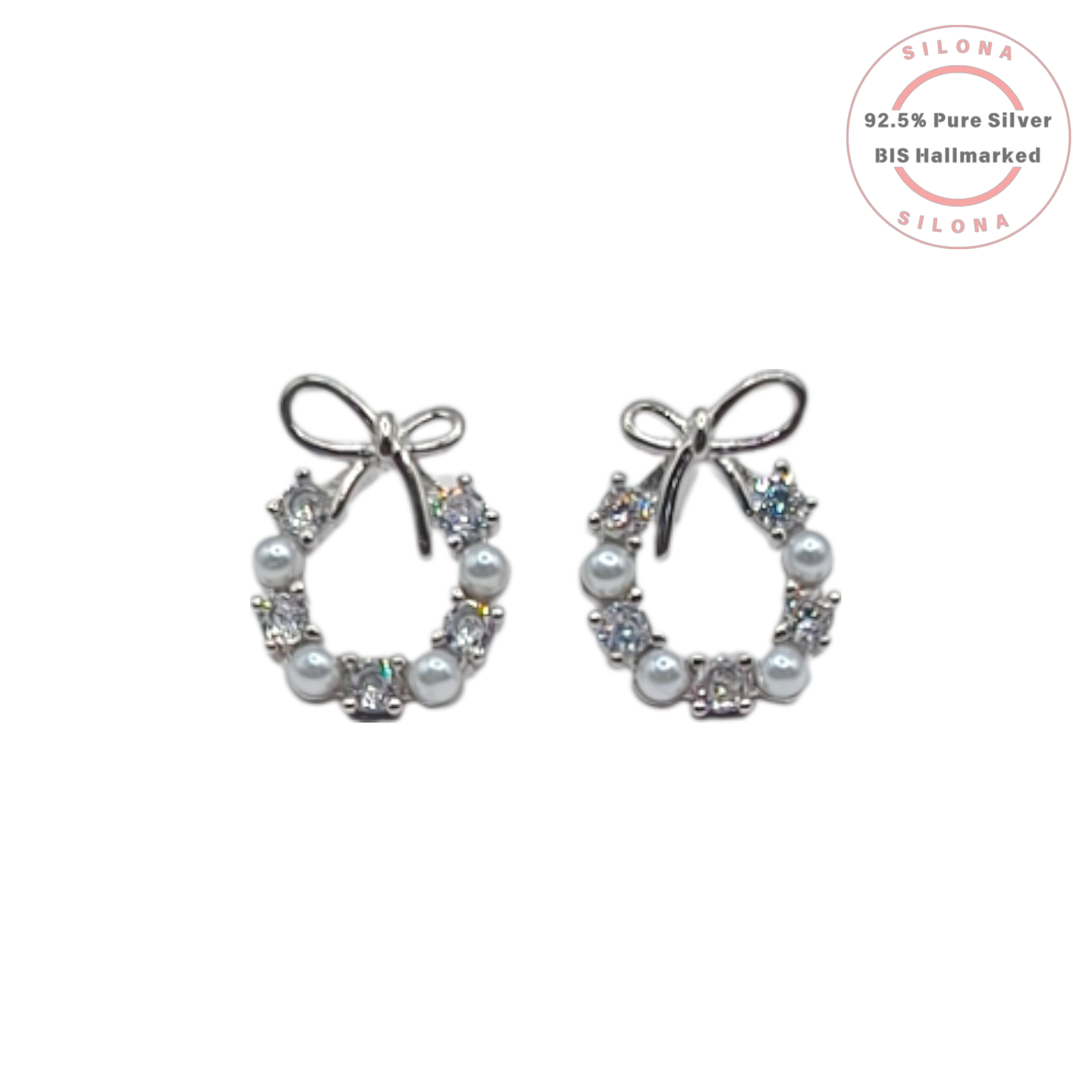 A pair of silver wreath stud earrings with alternating pearls and cubic zirconia, topped with a delicate silver bow, on a white background with a Silona hallmarking logo.