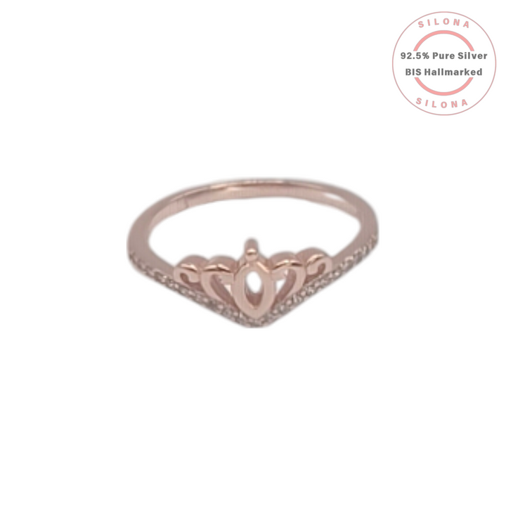 A delicate rose gold ring shaped like a royal crown with a pavé band of cubic zirconia, on a white background with a Silona hallmark.