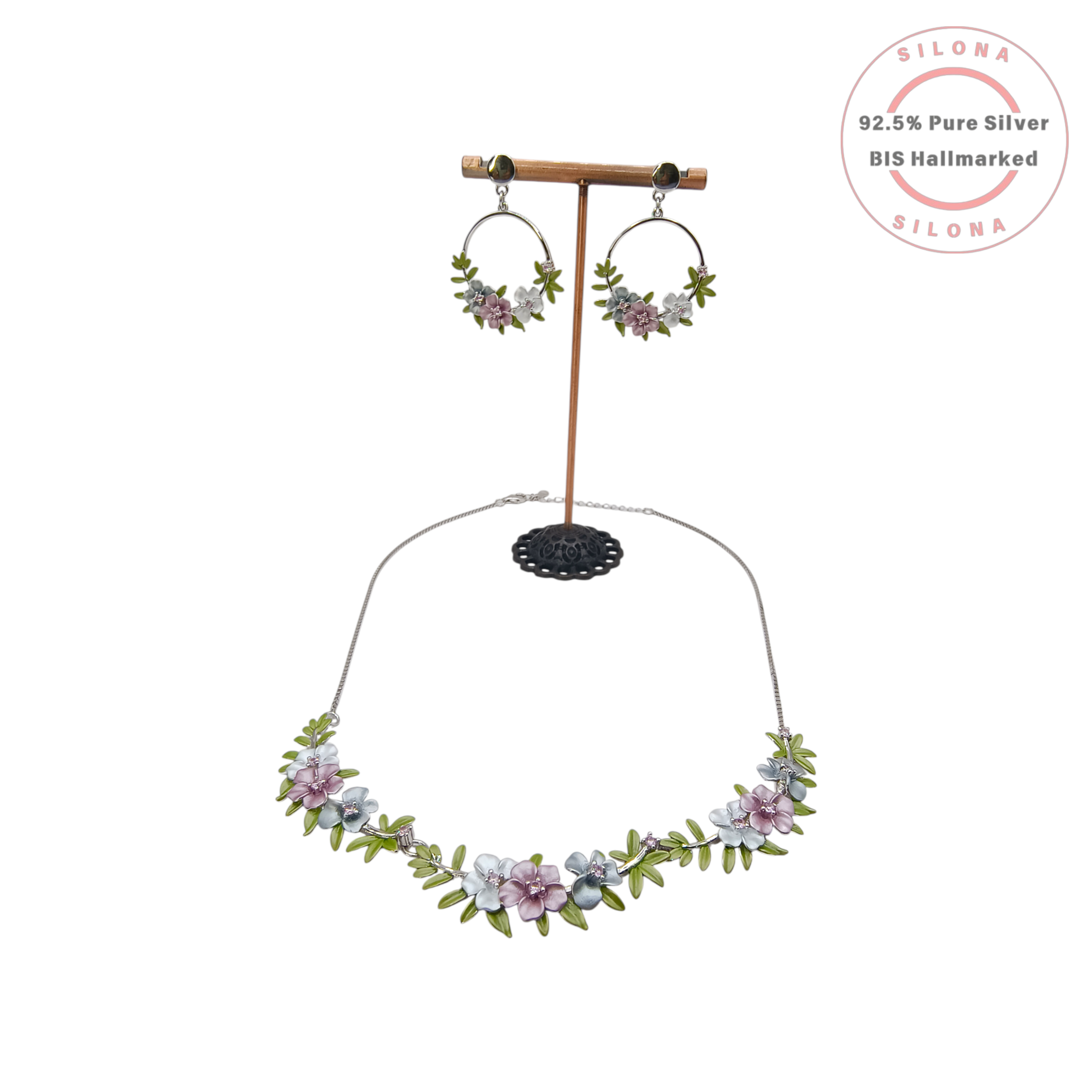 Pastel floral enamel necklace and matching hoop earrings set in 92.5 silver, displayed on a stand against a white background.