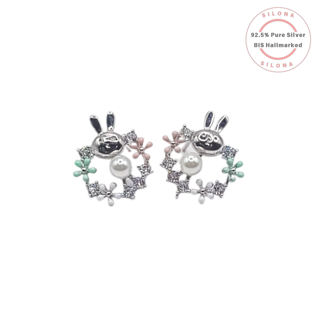 A pair of sterling silver stud earrings shaped like a bunny inside a floral wreath, detailed with pastel pink and green enamel, a pearl, and cubic zirconia stones.