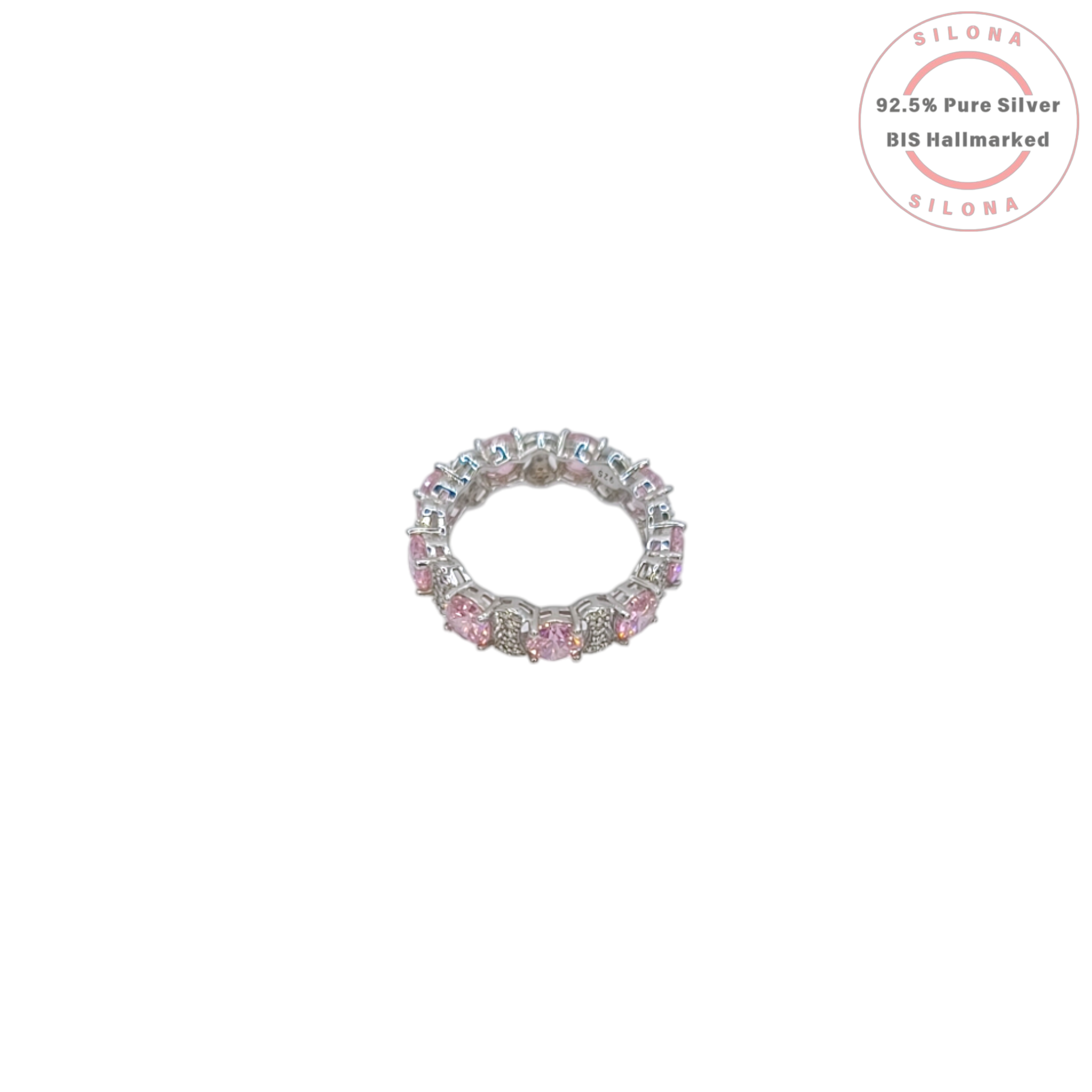A silver eternity ring featuring large, round, blush pink cubic zirconia stones, interspersed with clusters of small clear pavé stones, on a white background.
