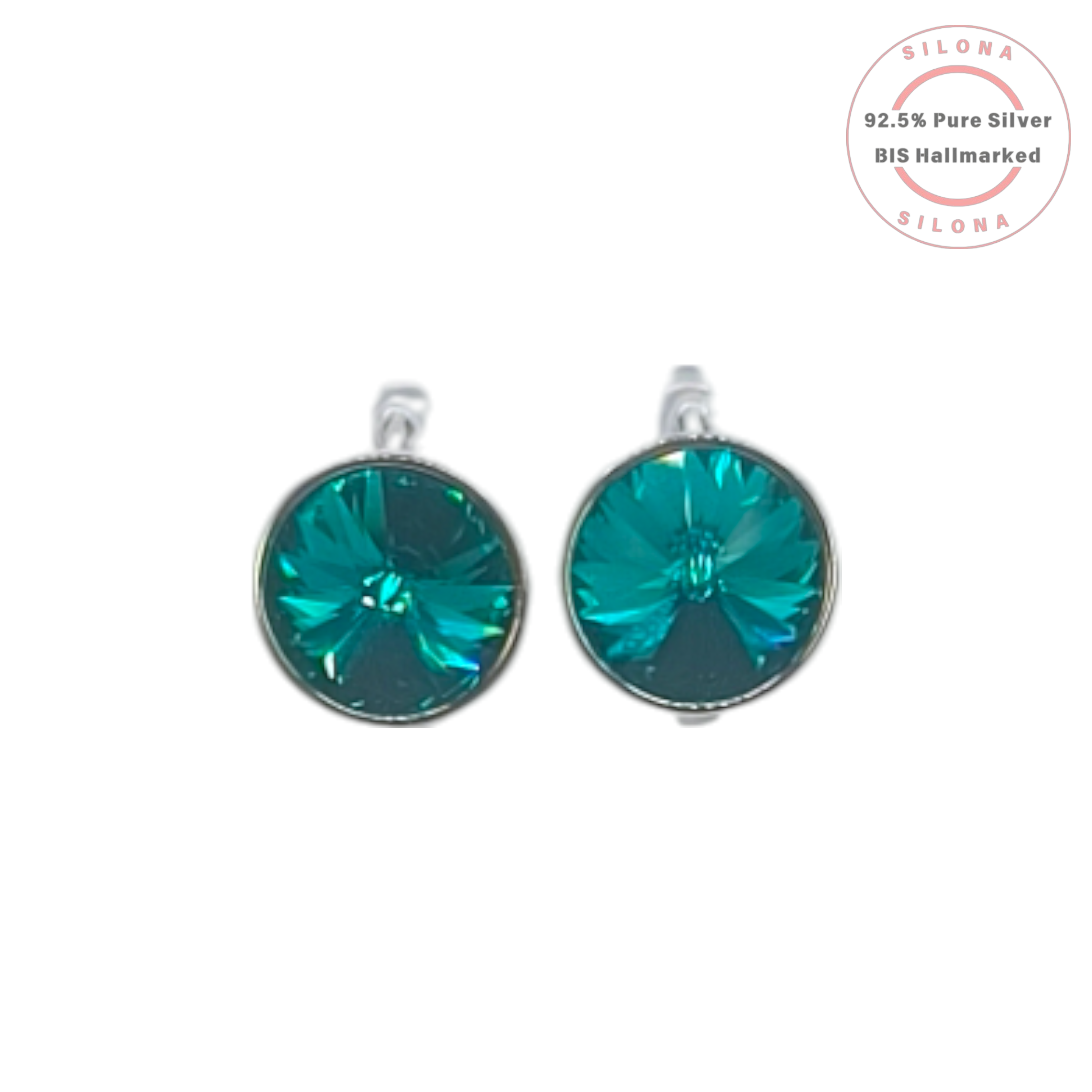 A pair of round solitaire earrings with large, faceted teal crystals set in sterling silver, shown against a white background with a Silona brand mark.