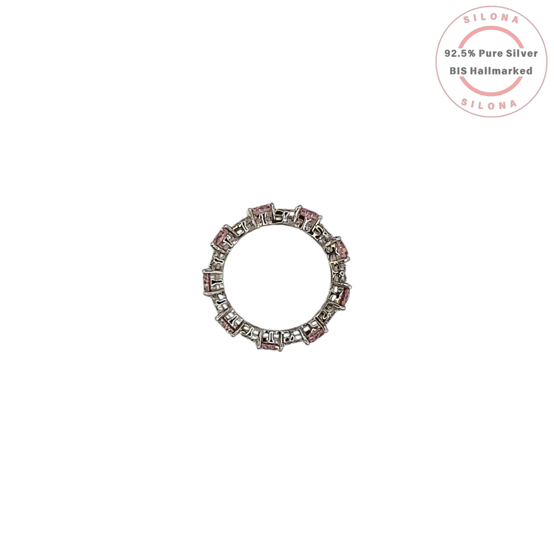 A silver eternity ring featuring large, round, blush pink cubic zirconia stones, interspersed with clusters of small clear pavé stones, on a white background.