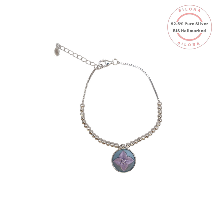 Silona's Lilac Floral Enamel Charm Bracelet in 92.5 silver, featuring a beaded chain and an adjustable clasp, shown on a white background.