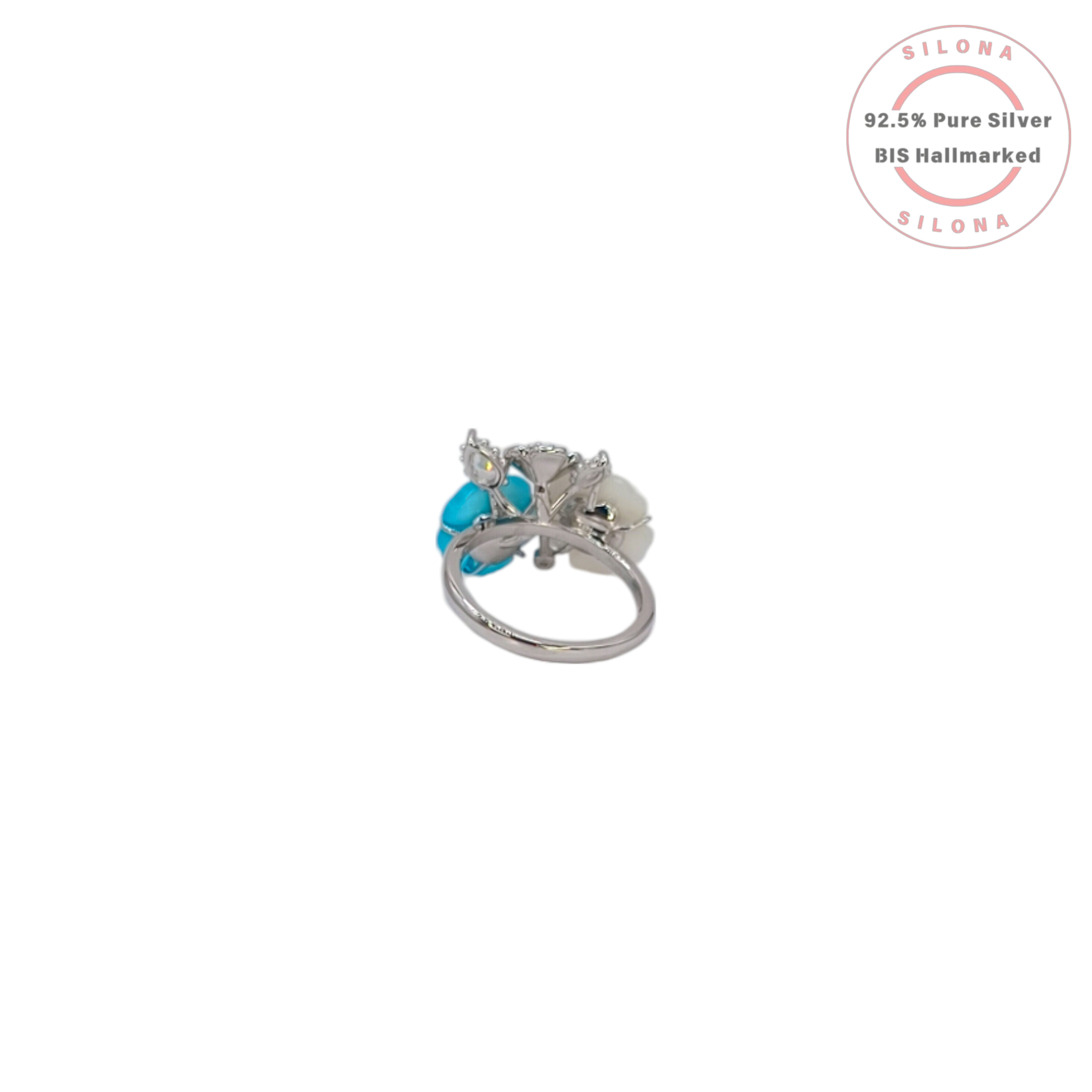Side view of a floral cluster ring in sterling silver, featuring turquoise blue and mother of pearl petals surrounding a central clear stone.