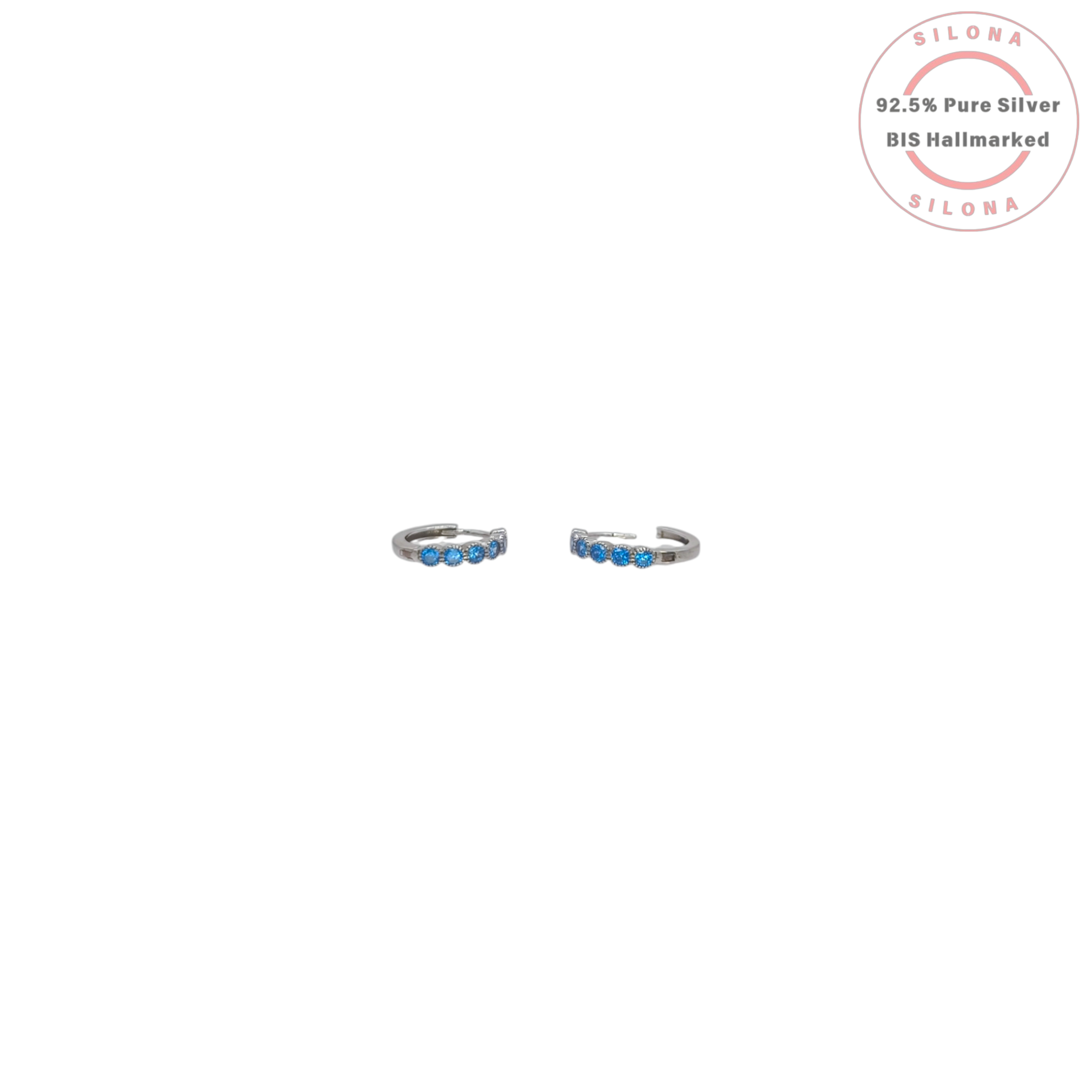 A pair of minimalist silver huggie hoop earrings, each set with a row of small, round, light blue cubic zirconia stones, on a white background with a Silona hallmark.