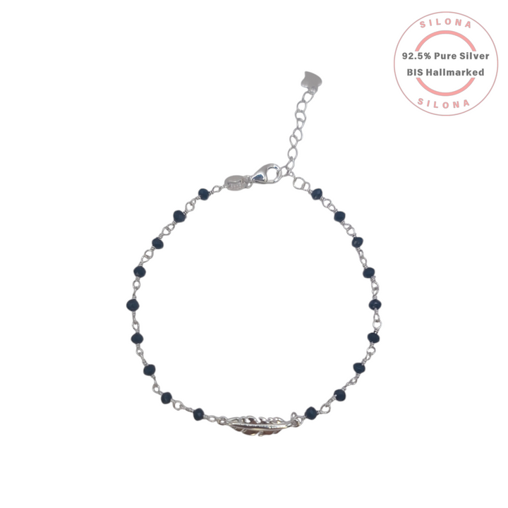 Delicate sterling silver bracelet featuring a central feather charm and faceted black beads on a link chain, shot on a white background with the Silona brand hallmark.