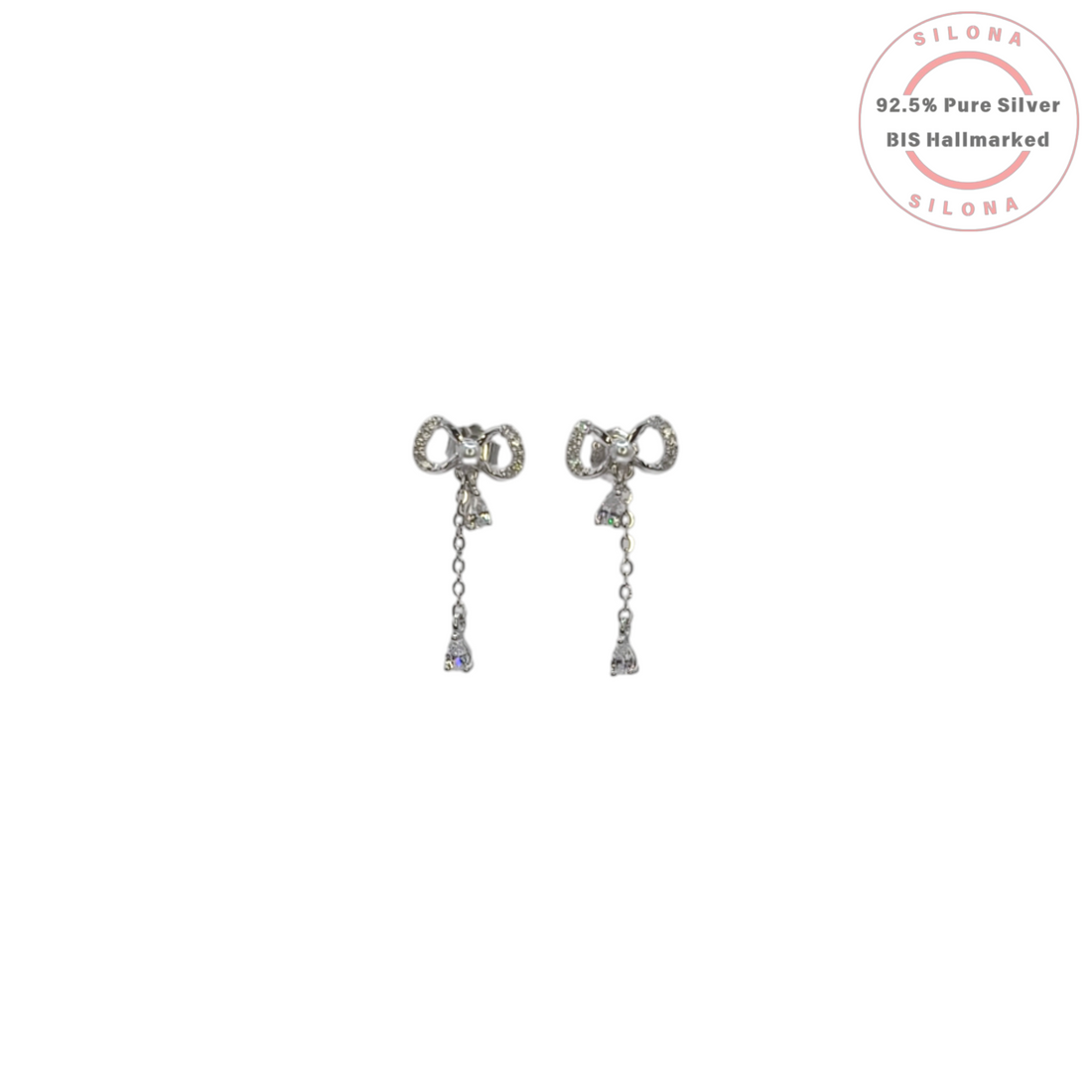 Pair of dainty silver bow drop earrings with pavé and pear-cut cubic zirconia on a white background.