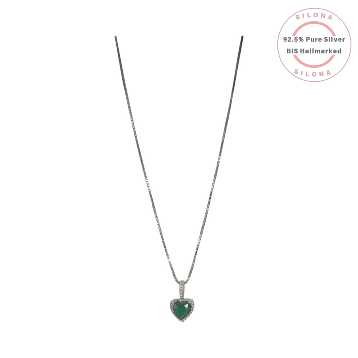 Silona's classic heart pendant necklace in 92.5 silver, featuring a central emerald-green stone surrounded by a halo of clear cubic zirconia, on a silver box chain.