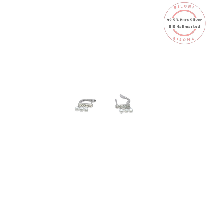 A pair of Modern Pearl Trio Huggie Earrings in 92.5 silver, featuring a pavé cubic zirconia bar and a cascade of three white pearls, on a white background.