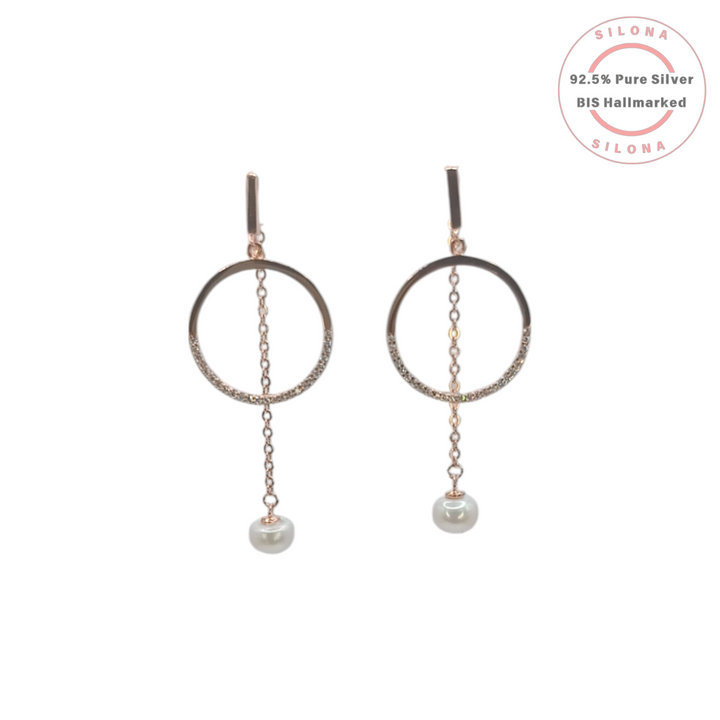 A pair of modern rose gold pearl drop hoop earrings on a white background. Each earring features a hoop with cubic zirconia and a dangling pearl.