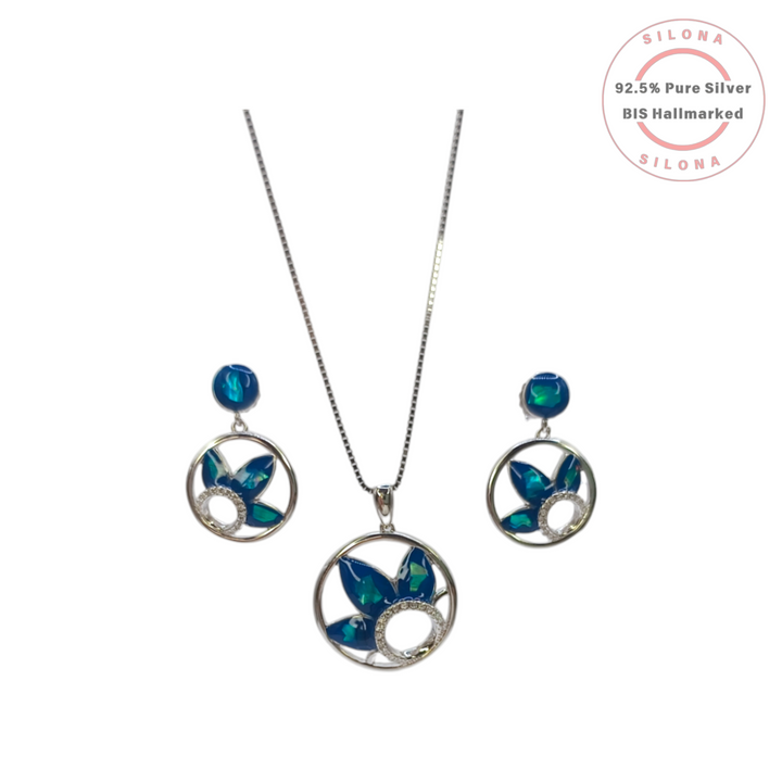 A pair of Silona's Azure Petal silver drop earrings, featuring a circular frame with peacock teal petals and a pavé cubic zirconia accent, on a white background.