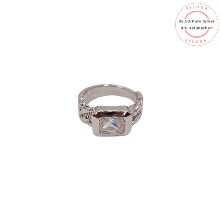 Front view of a modern emerald cut solitaire ring with a curb link style band, crafted in 92.5 sterling silver on a white background.