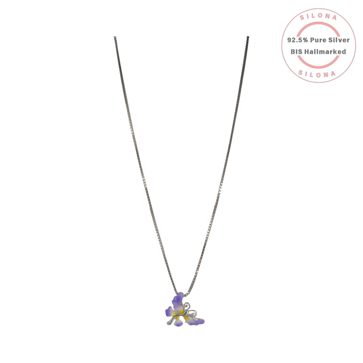 A delicate silver box chain necklace featuring a purple and yellow enamel iris flower pendant against a white background.