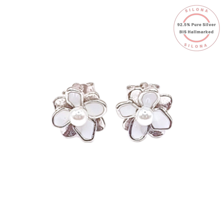 A pair of Silona Dainty Pearl Bloom Stud Earrings, crafted from 92.5 silver, featuring white enamel floral petals and a central pearl, on a white background.