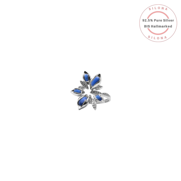 A modern floral statement ring in 92.5 silver, featuring marquise-cut sapphire-blue stones and pavé cubic zirconia, on a white background.