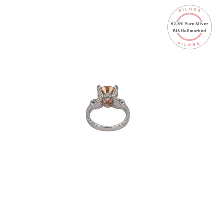 Front view of a statement solitaire ring with a large, round-cut champagne cubic zirconia on a pavé-detailed 92.5 silver band.