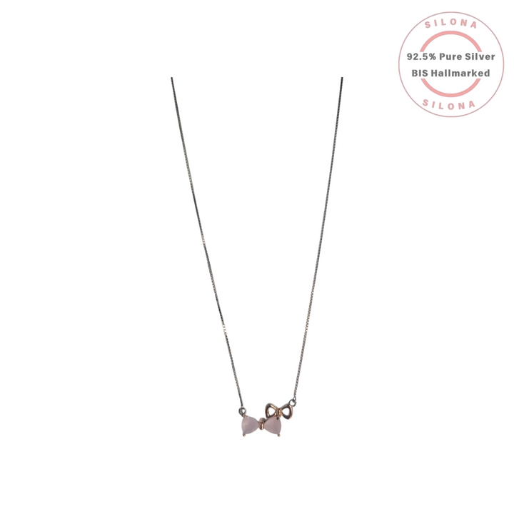 Delicate 92.5 silver box chain necklace with a double bow pendant featuring pale pink stones and a rose-gold accent, on a white background.