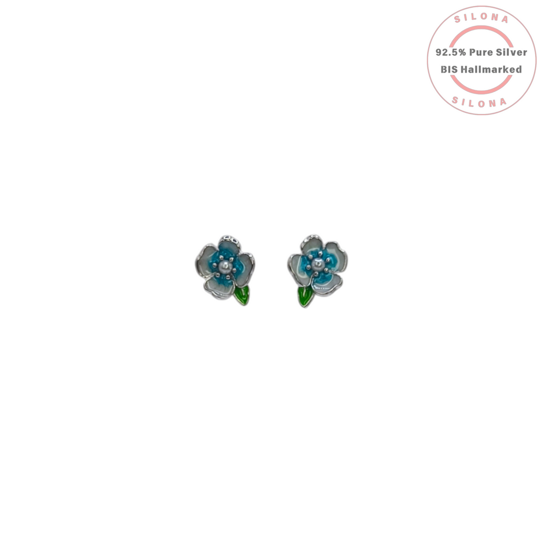 A pair of Silona silver stud earrings shaped like small blue and white enamel flowers with a green leaf, on a white background.