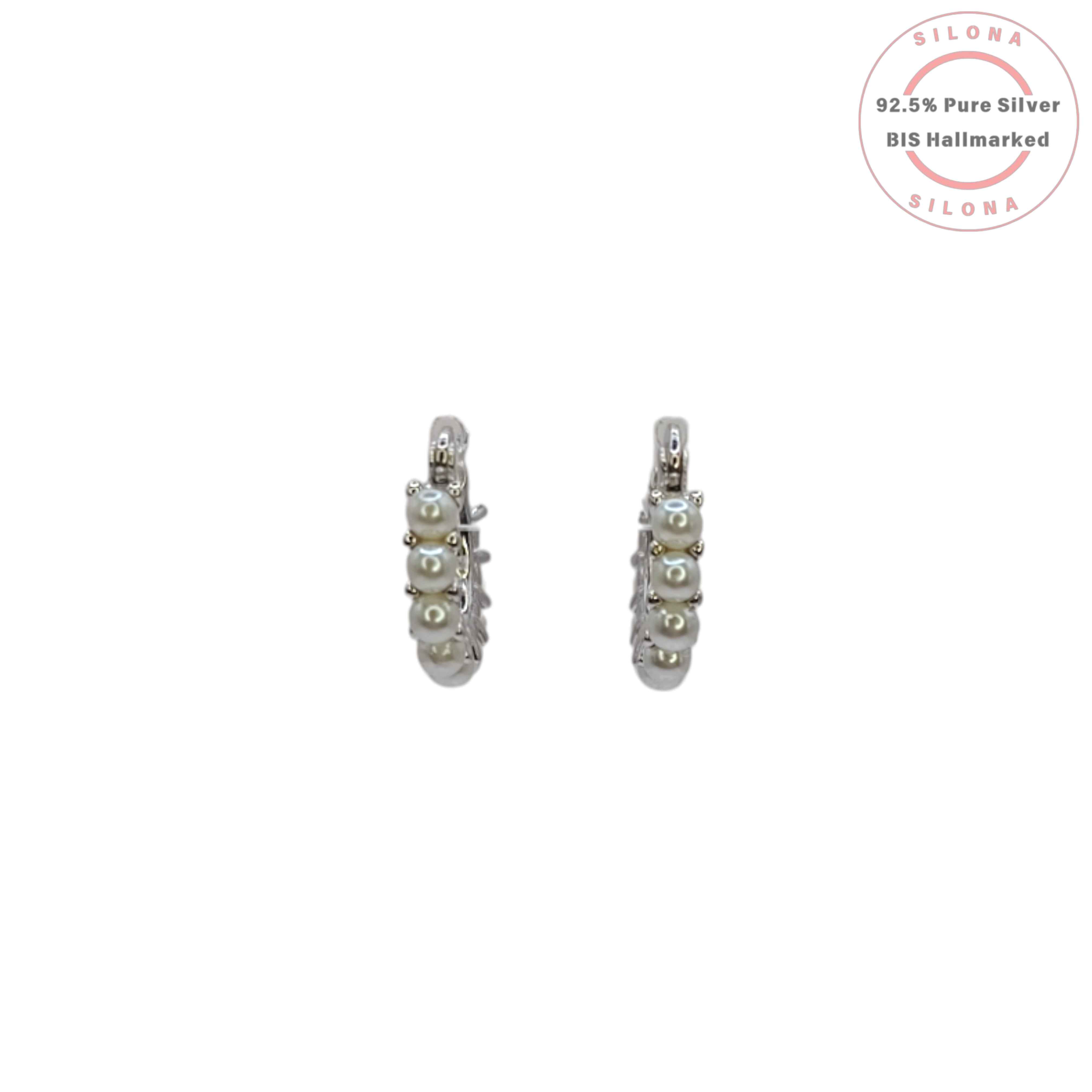 A pair of modern silver huggie hoop earrings, each adorned with a row of small white pearls, on a white background.