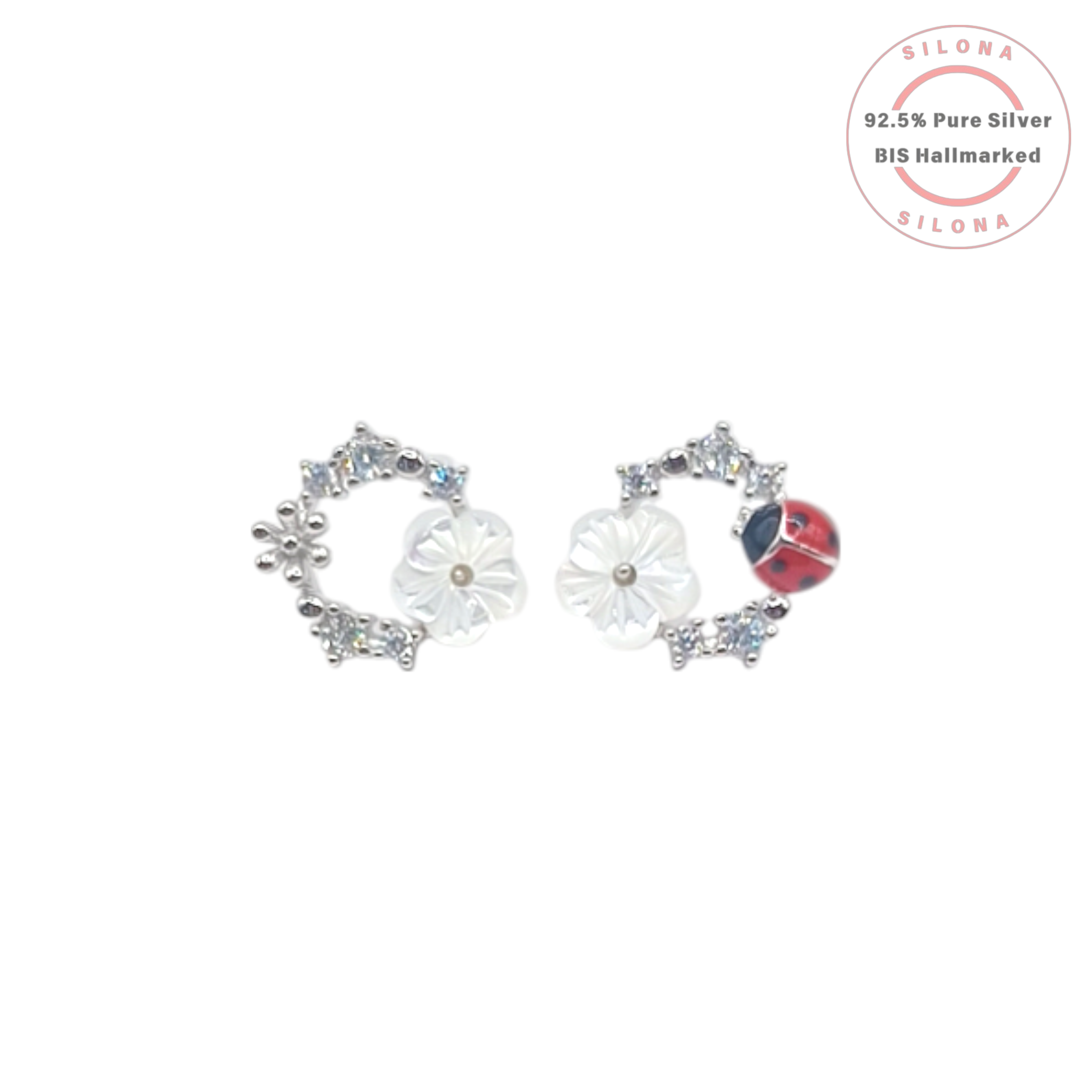 A pair of asymmetrical silver stud earrings, one with a mother-of-pearl flower and the other with a red enamel ladybug, both accented with sparkling cubic zirconia.