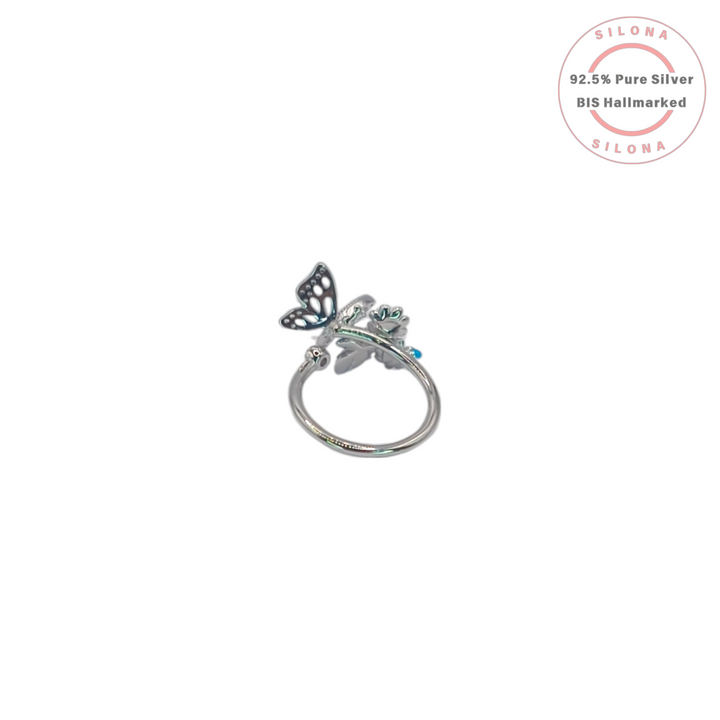 A sterling silver ring featuring a pavé cubic zirconia butterfly alongside a trio of pastel pink enamel flowers, shown on a white background.