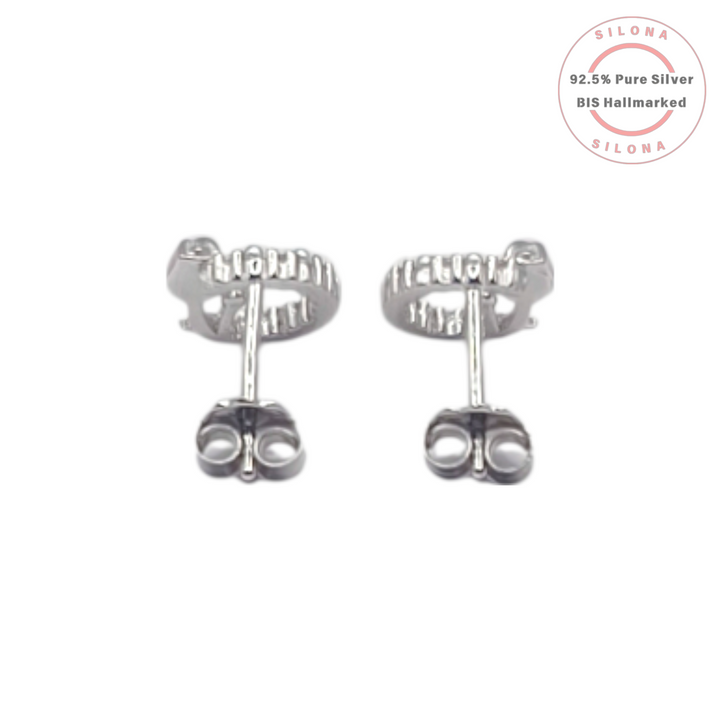 A pair of Silona silver stud earrings featuring a blush-pink enamel tulip inside a wreath of tiny white pearls, on a white background.