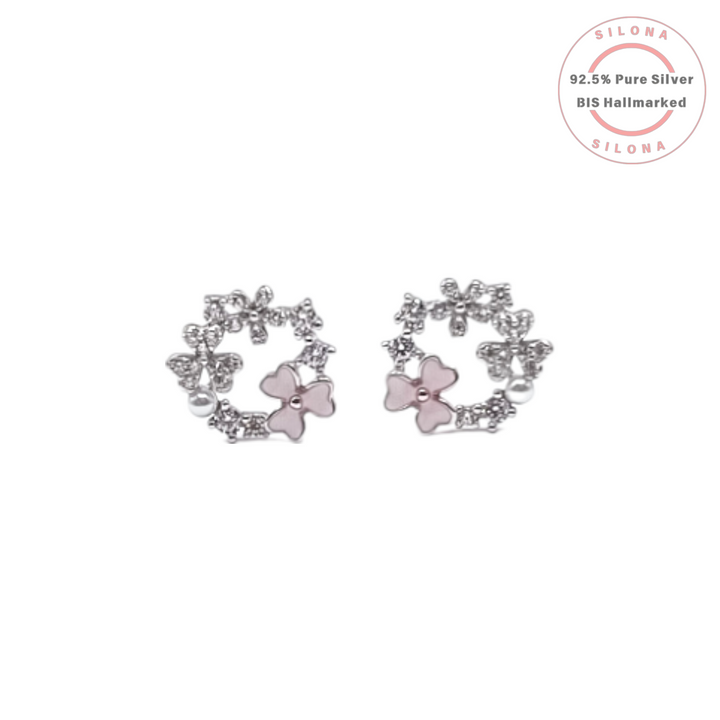 A pair of silver floral wreath stud earrings with pink mother-of-pearl flowers, cubic zirconia, and a small white pearl accent, on a white background.