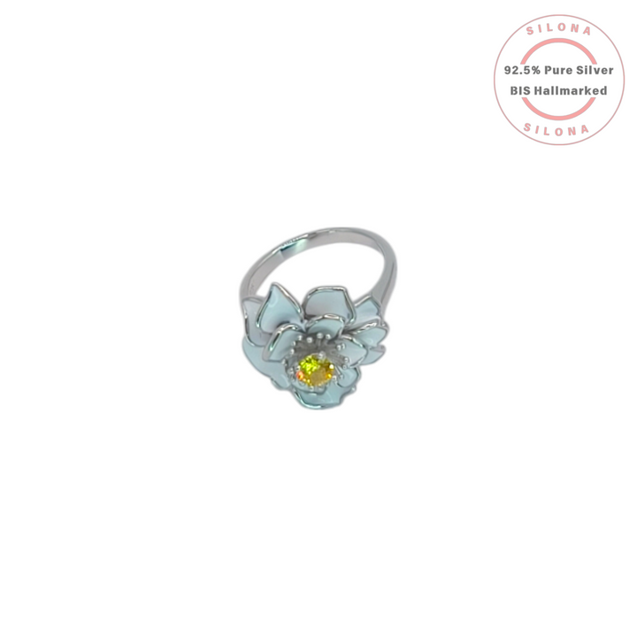 Silona Pastel Bloom Ring in 92.5 silver, featuring a flower design with light blue enamel petals and a central yellow cubic zirconia stone, on a white background.