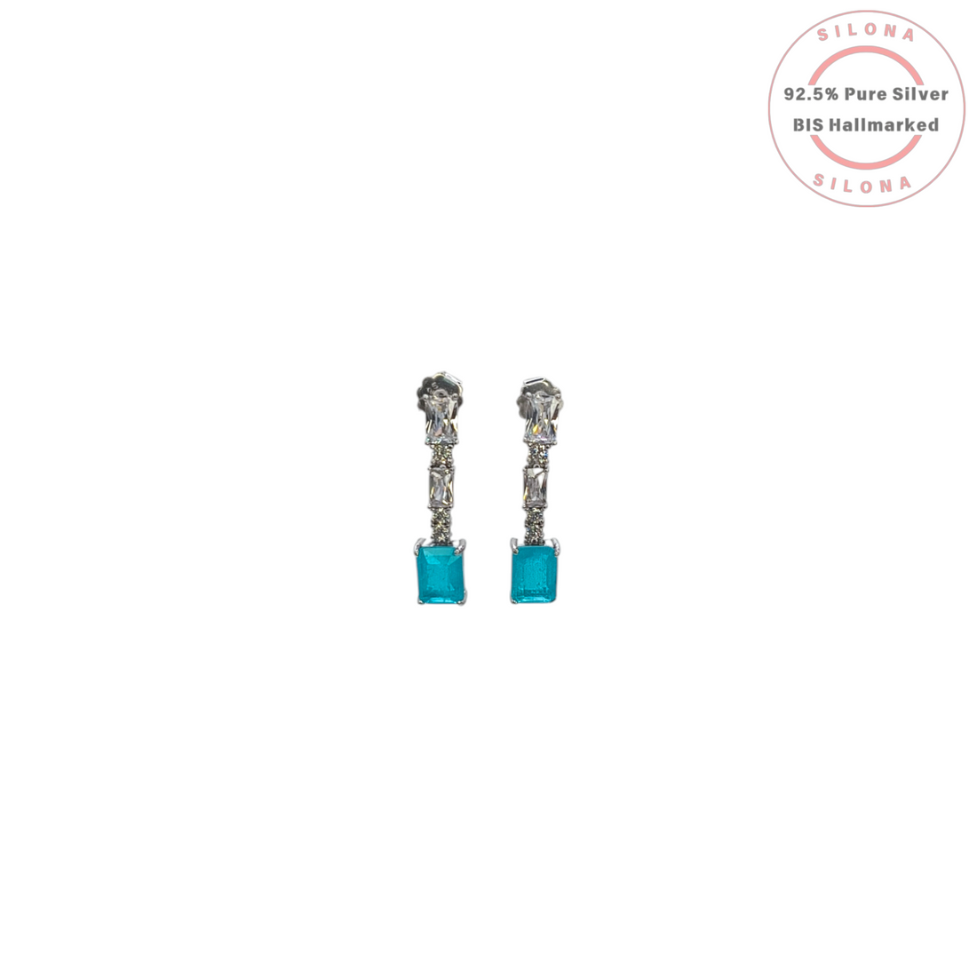 A pair of modern silver drop earrings with clear baguette-cut stones and a large rectangular aqua blue cubic zirconia stone at the drop, on a white background.
