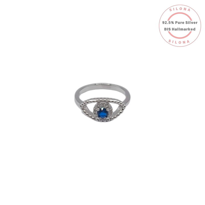 A sterling silver evil eye ring with a central sapphire-blue cubic zirconia stone surrounded by a halo of clear stones on a polished band.