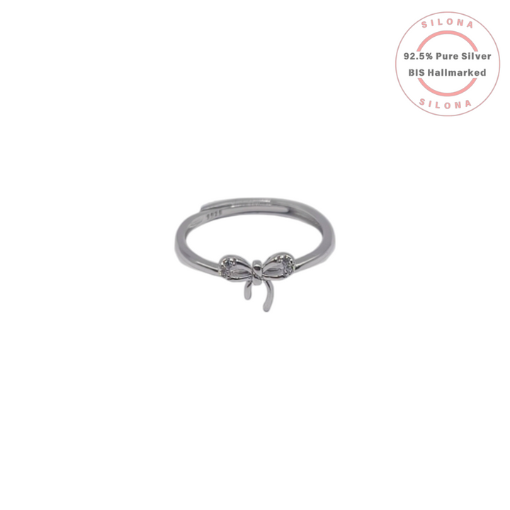 A minimalist Dainty Bow Ring crafted in 92.5 sterling silver, featuring a delicate bow motif studded with sparkling Cubic Zirconia, shown on a white background.