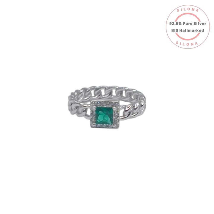 Modern chain link silver ring with a square emerald-green stone in a halo setting on a white background.