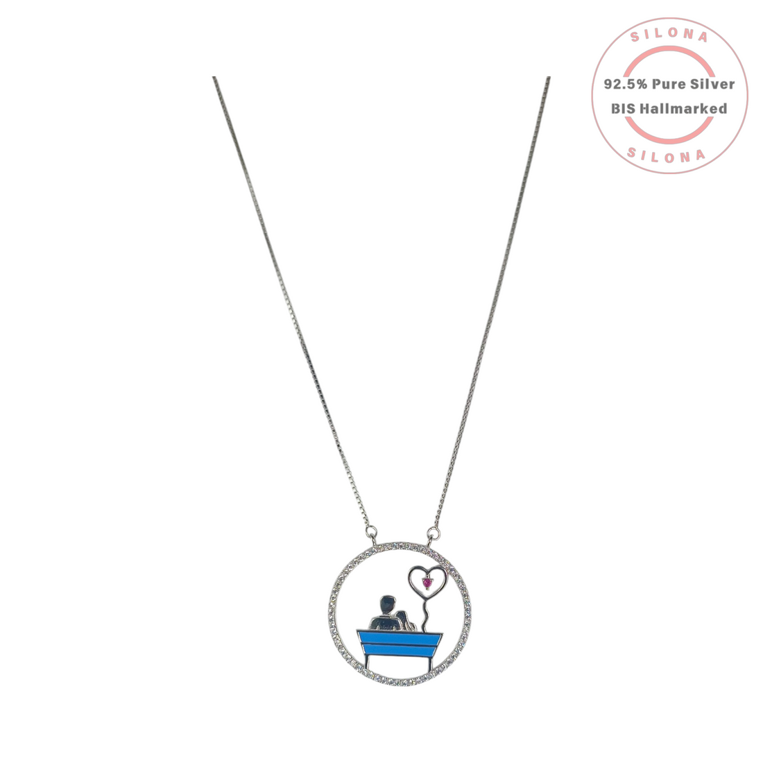 Silona's Enameled Couple Love Bench Necklace in 92.5 silver, featuring a couple on a blue bench with a pink heart balloon, on a white background.