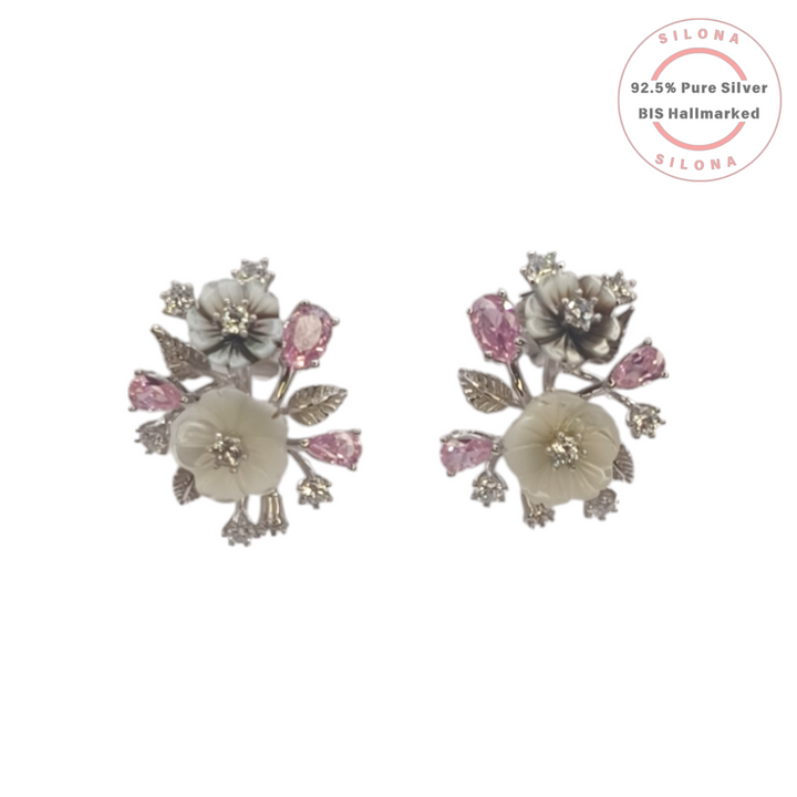 Pair of Silona silver floral bouquet stud earrings featuring carved mother-of-pearl flowers, pink pear-cut stones, and clear crystal accents on a white background.