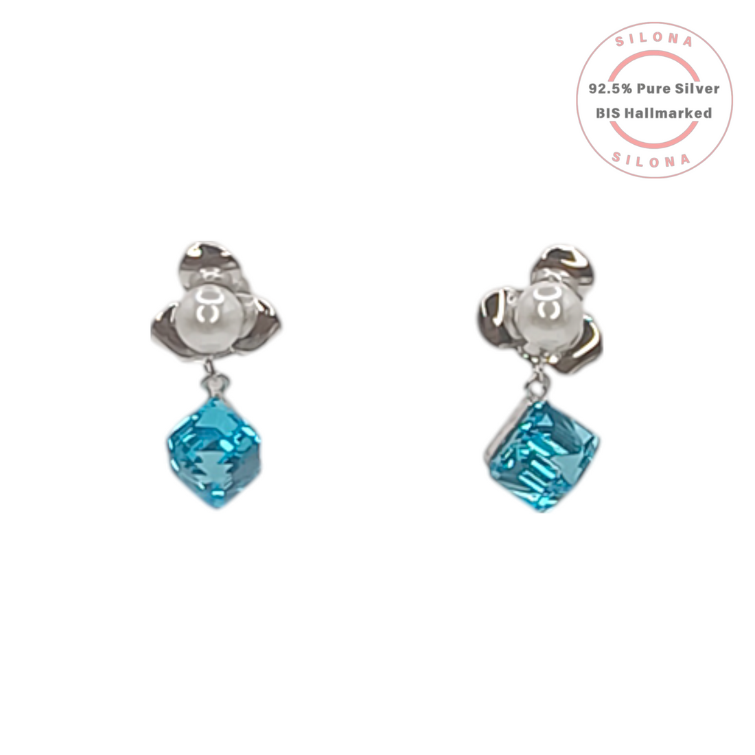 A pair of Silona silver drop earrings with a floral pearl stud and a dangling square-cut aquamarine blue crystal, on a white background.