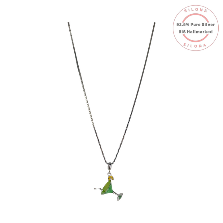 A silver box chain necklace featuring a playful martini glass pendant with green enamel and a yellow lemon detail.
